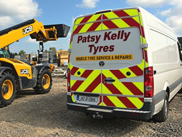 Back of the Patsy Kelly Tyres van with red and lime chevrons
